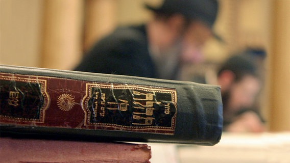 Das Symbolbild für die Sendung "Schabat Schalom" zeigt alte Bücher und lesende Rabiner im Hintergrund. © dpa-report Foto: Tobias Felber