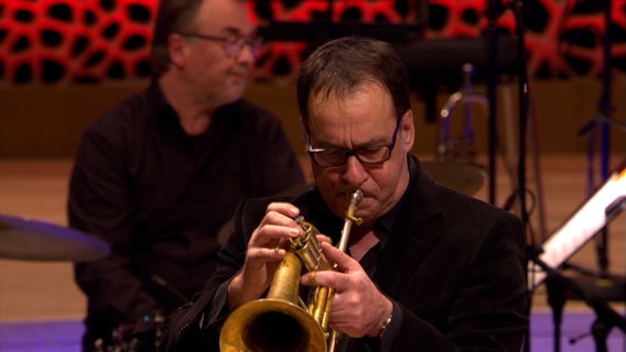 Screenshot: Claus Stötter von der NDR Bigband spielt beim Konzert "American Cool Jazz" in der Elbphilharmonie Hamburg das Flügelhorn. © NDR Bigband Foto: Screenshot