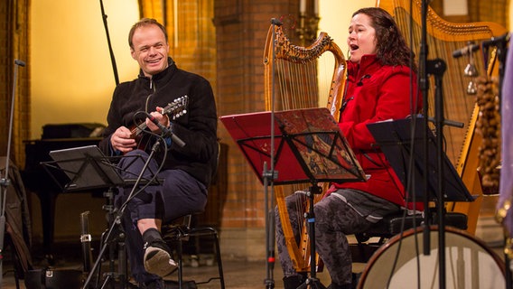Petter Udland lacht, neben ihm sitzt Arianna Savall - im roten Wollmantel - an der Harfe. © NDR Foto: Axel Herzig
