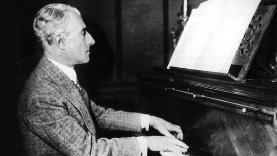 Der Komponist Maurice Ravel spielt Klavier. © picture alliance / Belga/dpa | Belga 