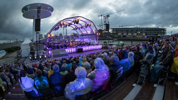 Blick über die Zuschauer auf der Tribüne auf die Bühne des HafenCity Open Air des NDR Elbphilharmonie Orchesters 2016 © NDR Foto: Axel Herzig