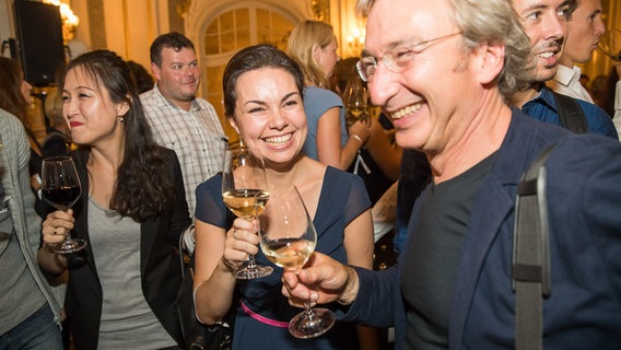 Bilder vom Empfang nach der Opening Night: Lachende Musiker stoßen mit Weingläsern an © NDR Foto: Axel Herzig