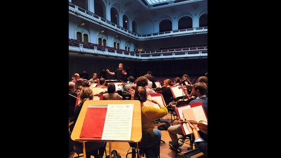 Blick vom Orchester aus auf den lettischen Dirigent Andris Poga bei der Probe  