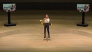 Screenshot: Hornistin Claudia Strenkert auf der leeren Bühne des Großen Saals in der Elbphilharmonie Hamburg © NDR Foto: Screenshot