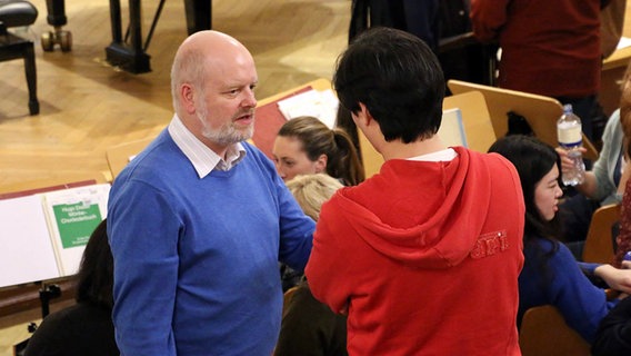 Probenpause: Chorsänger Joachim Duske im Gespräch mit einem Gesangsstudenten © NDR Foto: Kristien Daled
