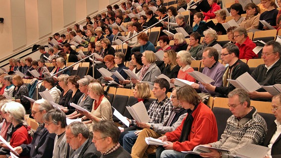 Chorsänger und -sängerinnen mit Noten in den Sitzreihen des Rof-Liebermann-Studios © NDR Foto: Kristien Daled
