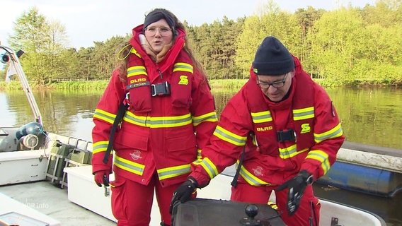 Zwei Einsatzkräfte der DLRG auf einem Boot. © Screenshot 