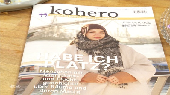 Eine Ausgabe des "Kohero"-Magazins liegt auf einem Tisch. Das Titelbild zeigt eine junge Frau mit Kopftuch und die Schlagzeile lautet "Habe ich Platz?". © Screenshot 