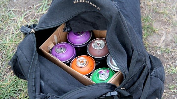 In einer Tasche sind sechs Spraydosen. © NDR Foto: Henning Martin