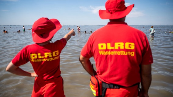Zwei Rettungsschwimmer vom DLRG stehen am Strand. © picture alliance/dpa | Sina Schuldt Foto: Sina Schuldt