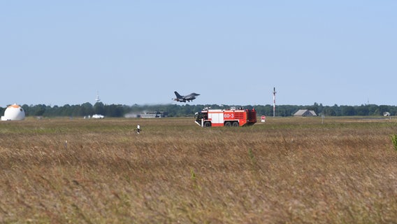 Ein amerikanischer F16-Kampfjet startet. Im Vordergrund ist die die Flugplatz-Feuerwehr zu sehen. © NDR Foto: Jörn Zahlmann