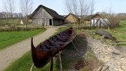 Ein Boot steht vor Häusern des Wikinger-Museums Haithabu. © dpa-Bildfunk Foto: Carsten Rehder