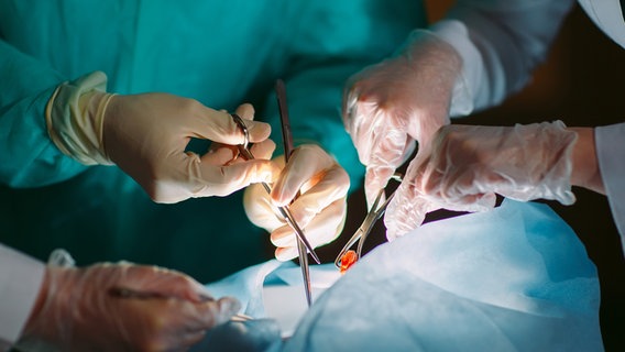 Hände mit medizinischen Geräten an einem OP-Tisch. © colourbox Foto: -