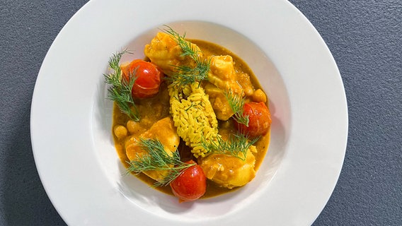 Rotbarsch-Filet in Curry-Kokosmilch auf einem Teller serviert © NDR 