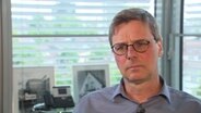 "Spiegel"-Journalist Matthias Bartsch gibt ZAPP in seinem Büro ein Interview. Er hat kurze, graue Haare, trägt eine Brille und ein graues Hemd. © NDR Foto: Screenshot
