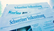 Drei Tageszeitungen liegen übereinander: Zwei Exemplare der Schweriner Volkszeitung und ein Exemplar des Kuriers. © Screenshot 
