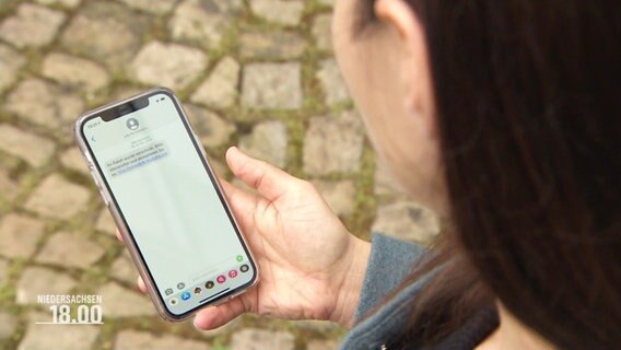 Eine Frau schaut auf ihr Mobiltelefon. © Screenshot 