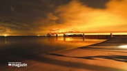 Ein bei Sonnenaufgang gemachtes Foto der Seebrücke in Scharbeutz. © Screenshot 
