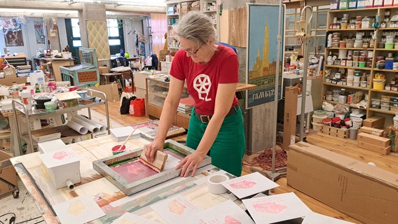 Ältere Frau vor Kunstwerken. Es ist die Dekorationsmalerin Friederike Schulz im Atelier. © NDR.de Foto: Petra Volquardsen