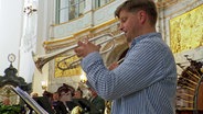 Ein Mann bläst in eine Trompete. © NDR 