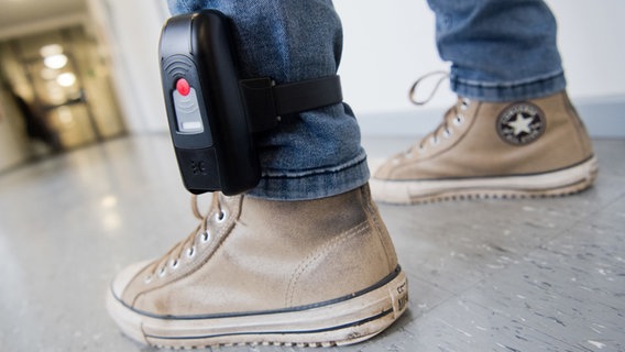 Ein Mann trägt eine elektronische Fußfessel. © dpa Foto: Julian Stratenschulte