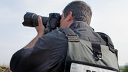 Professioneller Photojournalist mit einer Weste mit Aufdruck "Press" fotografiert. © picture alliance / Photoshot | 
