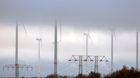 Parchim: Tief hängende Wolken ziehen über Anlagen in einem Windpark. © Jens Büttner/dpa +++ dpa-Bildfunk +++ Foto: Jens Büttner/dpa +++ dpa-Bildfunk +++