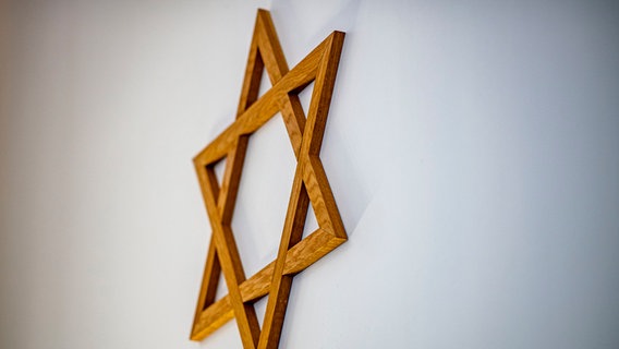 Ein Davidstern hängt an einer Wand im Gebetsraum einer Synagoge. © dpa Foto: David Inderlied