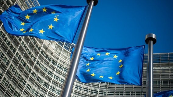 Flaggen der Europäischen Union wehen im Wind vor dem Berlaymont-Gebäude, dem Sitz der Europäischen Kommission. © dpa-Bildfunk Foto: Arne Immanuel Bänsch