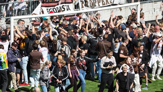Fans des FC St. Pauli demontieren nach dem Schlusspfiff die Tornetze, um sich ein Erinnerungsstück des Aufstiegs 2024 zu sichern. © IMAGO / osnapix 