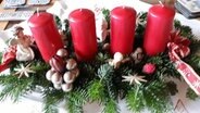 Ein Adventskranz mit vier roten Kerzen auf einem Tisch. © NDR Foto: Gisela Seib