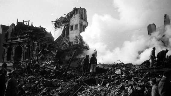 Menschen stehen vor rauchenden Trümmern nach den Luftangriffen auf Hamburg 1943 © Uwe Petersen Foto: Andreas Werner