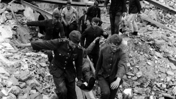 Opfer eines Bombenangriffs 1943 wird von Helfern auf einer Trage aus den Trümmern eines Hauses getragen © Uwe Petersen Foto: Andreas Werner