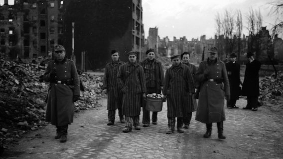 Von Soldaten begleitete KZ-Häftlinge bei Aufräumarbeiten in den Trümmern nach den Luftangriffen auf Hamburg 1943 © Uwe Petersen Foto: Andreas Werner