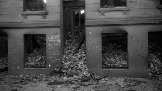 "Wir leben alle" steht handgeschrieben mit Kreide am Eingang eines von den Luftangriffen auf Hamburg zerstörten Hauses © Uwe Petersen Foto: Andreas Werner