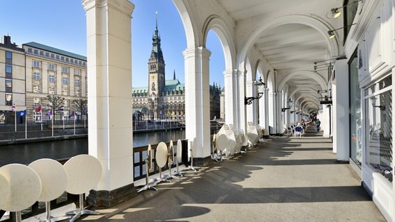 Blick durch einen Torbogen der Alsterarkaden auf das Hamburger Rathaus © fotolia Foto: kameraauge