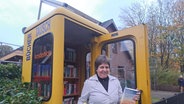 Carmen Speck steht vor der Büchertausch-Telefonzelle in Langenhorn © NDR Foto: Petra Volquardsen
