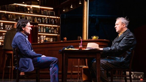 Schauspieler Oliver Mommsen und Stephan Grossmann auf Stühlen auf einer Bühne © Kerstin Schomburg Foto: Kerstin Schomburg