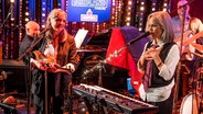 Eine Band auf einer Bühne in einem Club. Die Sängerin steht vor einem Keyboard. Vor ihr ein Mikrofon. © San Glaser Foto: Jörg-Martin Schulze