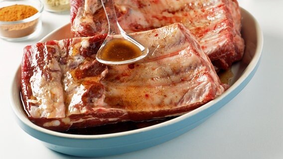Marinade wird über Spare Ribs geträufelt. Marinade wird über Spare Ribs geträufelt. © Picture Alliance Foto: Riou