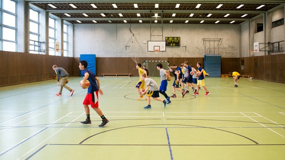 Kinder spielen Basketball in einer Sporthalle. © picture alliance / dpa Foto: Felix Zahn