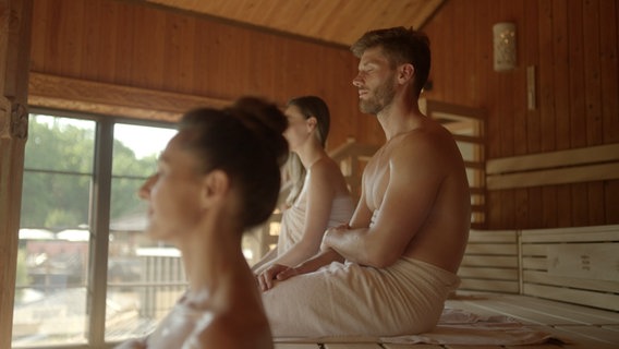 Menschen sitzen in einer Sauna im vabali spa Hamburg. © vabali spa Hamburg Foto: Screenshot