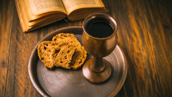 Brot, Wein und eine Bibel liegen auf einem Holztisch. © picture alliance / Zoonar | Ingrid Balabanova Foto: Ingrid Balabanova
