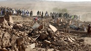 Afghanische Männer suchen nach einem Erdbeben in der Provinz Herat im Westen Afghanistans nach Opfern. © Omid Haqjoo/AP/dpa 