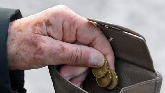 A pensioner takes small change out of a wallet.  © picture alliance/dpa Photo: Stephanie Pilick