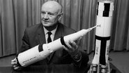Der Deutsche Raketenexperte Arthur Rudolph hält ein Modell der Saturn V Rakete in den Händen. © https://commons.wikimedia.org/wiki/File:Arthur_Rudolph.jpg 