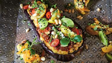An eggplant stuffed with vegetables and red sauce lies on a tray © ZS/Jo Kirchherr Photo: Jo Kirchheer