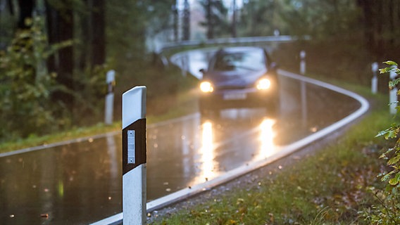 Ein Auto fährt im Regen auf einer kurvigen Waldstraße. © fotolia Foto: Tobias Arhelger