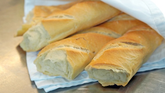 Drei Baguette-Brote auf einem weißen Küchentuch. © NDR Foto: Florian Kruck
