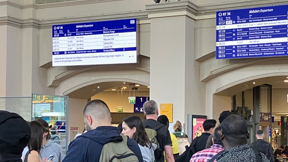 Bahnreisende schauen auf Abfahrtstafel im Bremer Hauptbahnhof. © NDR Foto: Maren Momsen